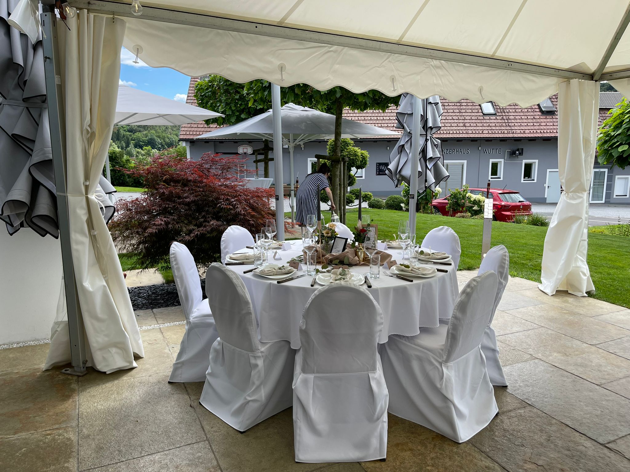 Runder Hochzeitstisch im Zelt mit Blick auf das Winzerhaus Wutte.